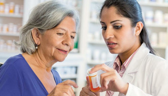pharmacist helping aging patient